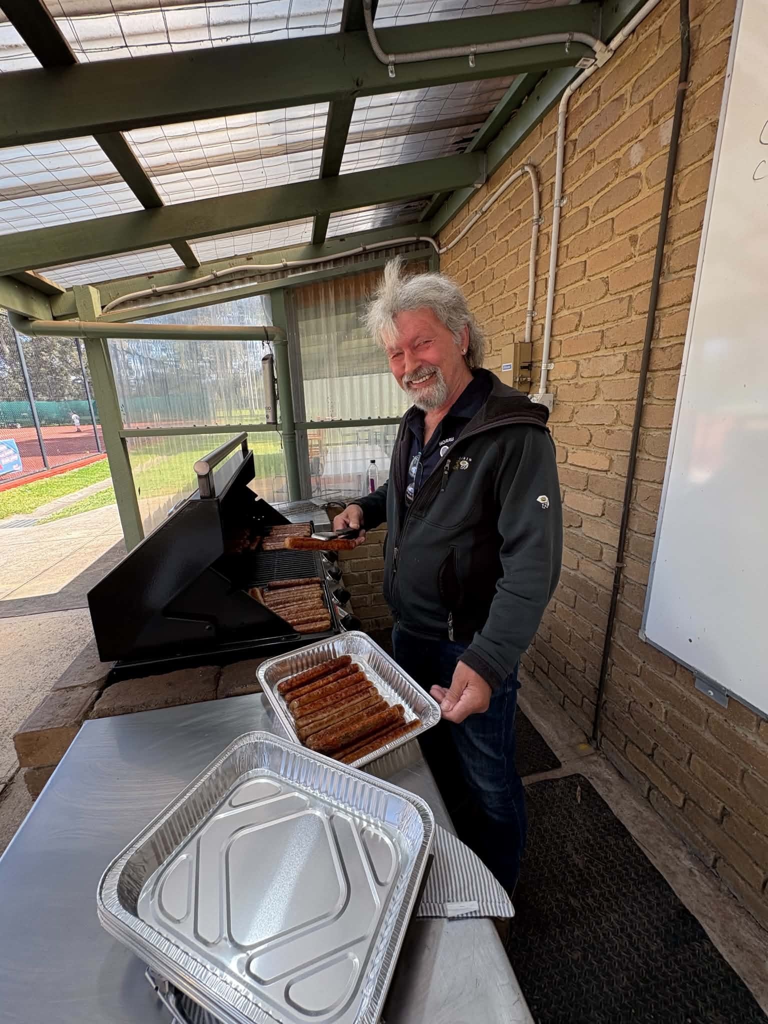 Volunteer manning the barbecue grill at Tennis Together Day
