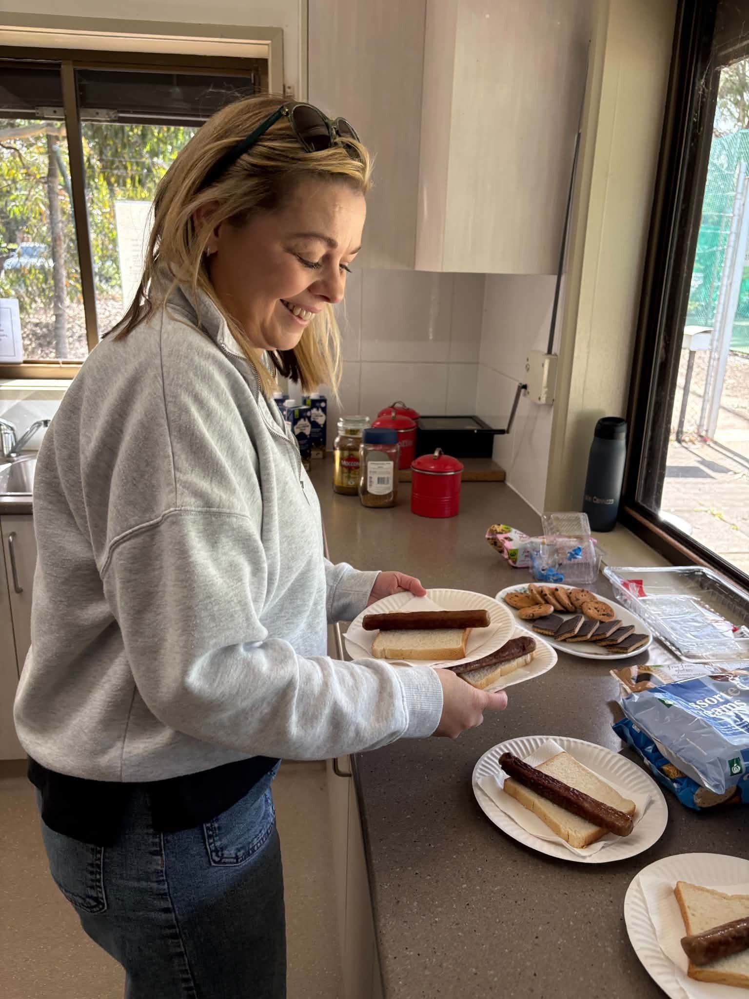 Volunteer preparing sausage sandwiches in the club kitchen