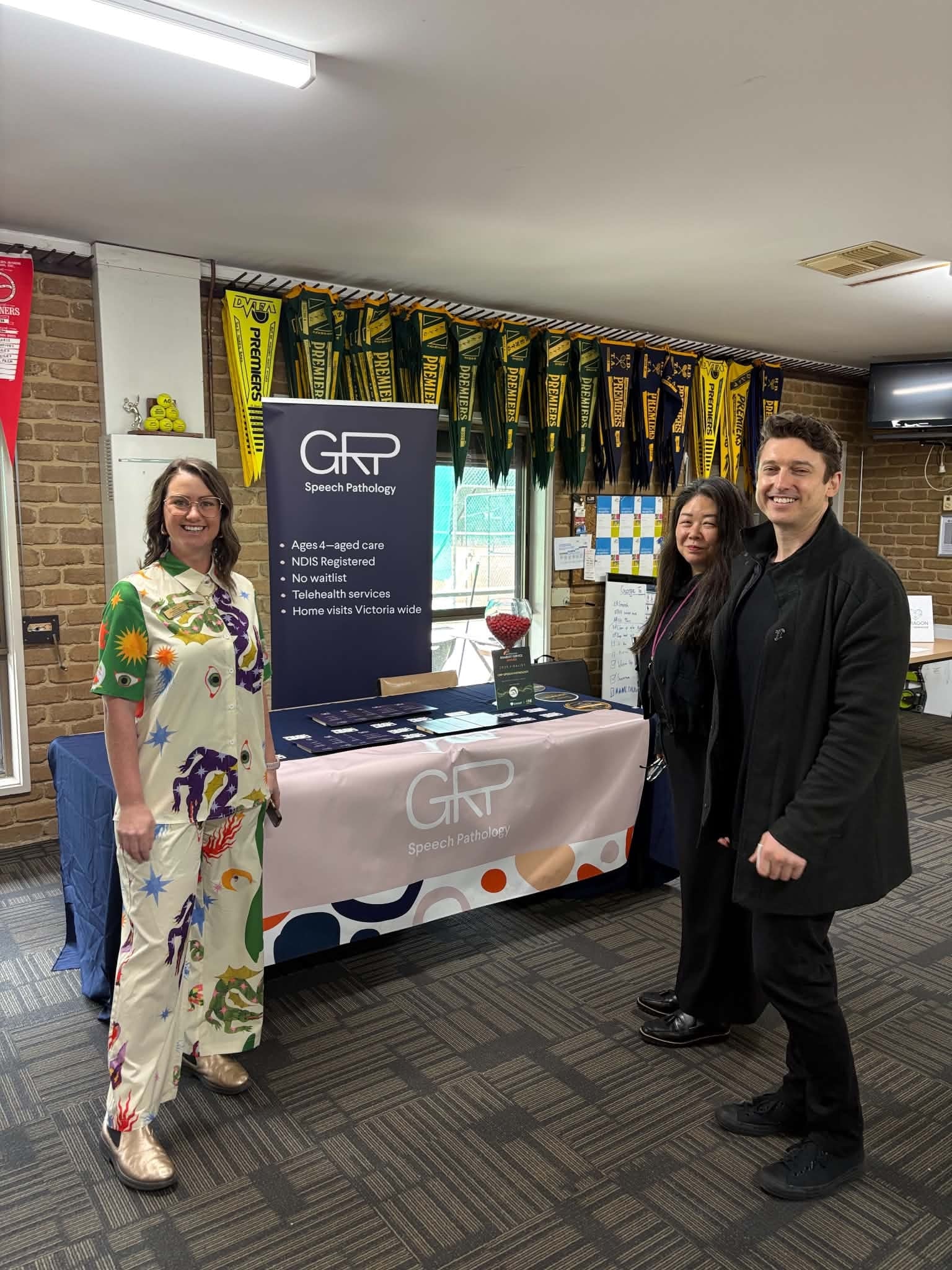 Three people at the GRP Speech Pathology exhibition booth