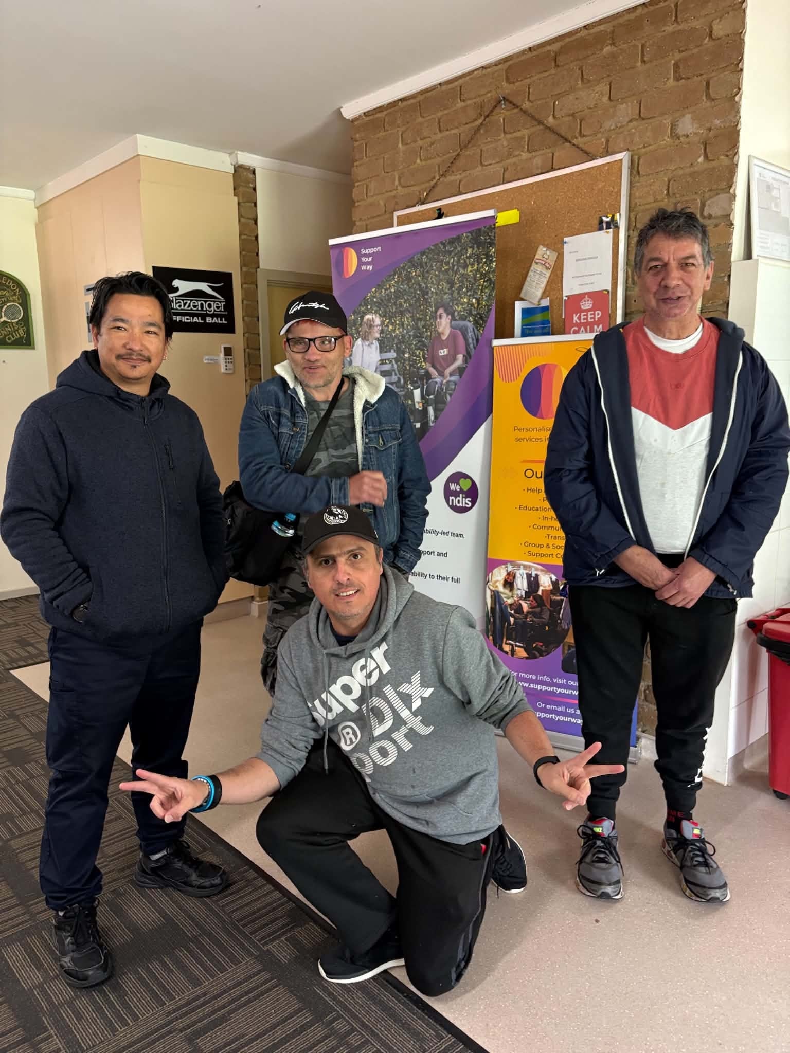 Four participants posing together inside the clubrooms at Tennis Together Day