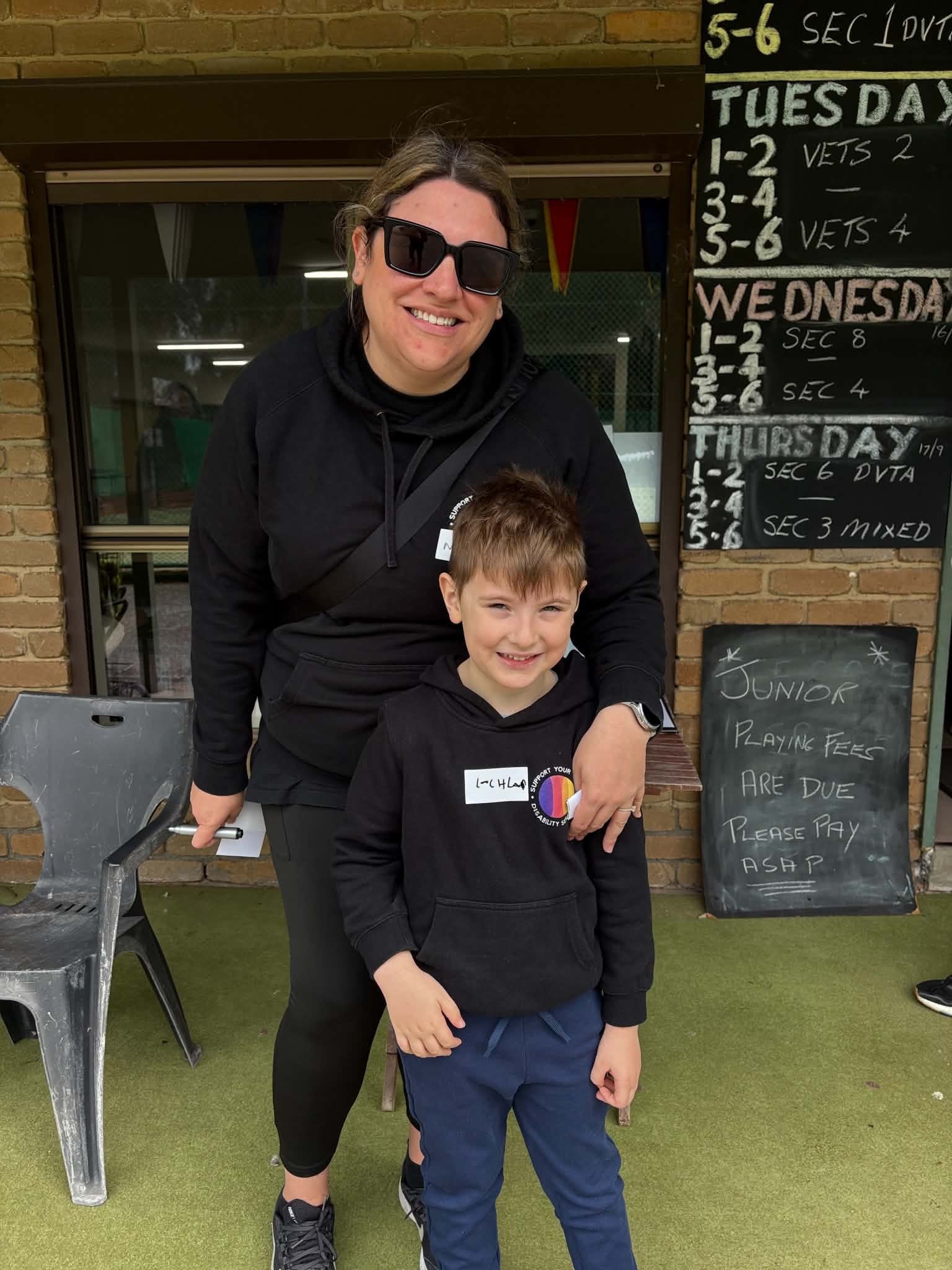 Woman and boy smiling together at the tennis club
