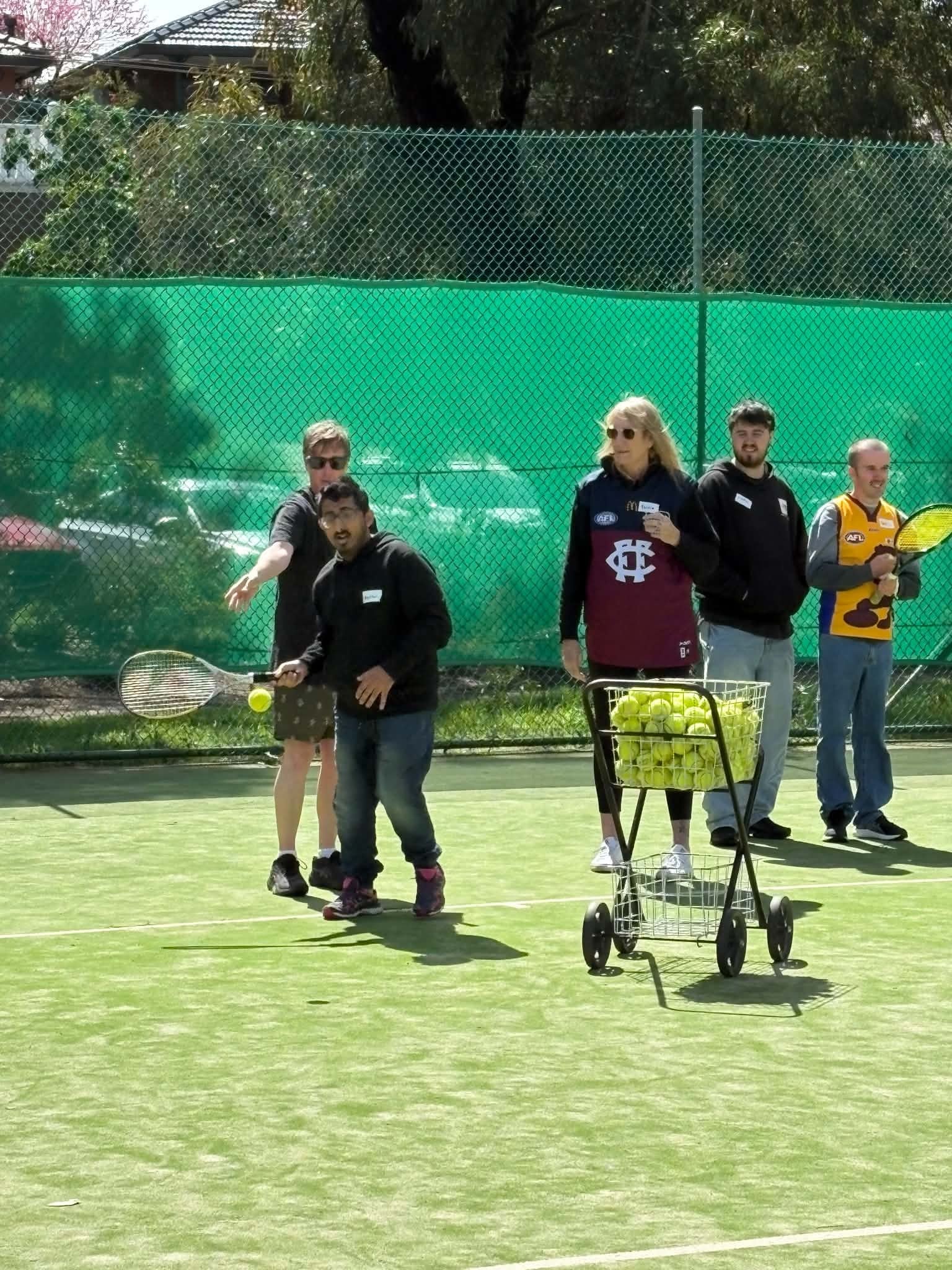 Group of participants playing tennis on the courts at Tennis Together Day