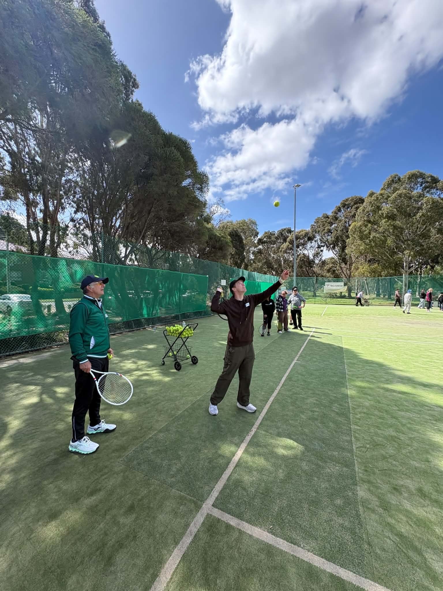 Participant practising a serve on the synthetic courts at Tennis Together Day
